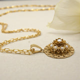 COLLANA CERCHIO TRAFORATO CON ROSA CENTRALE E PERLE